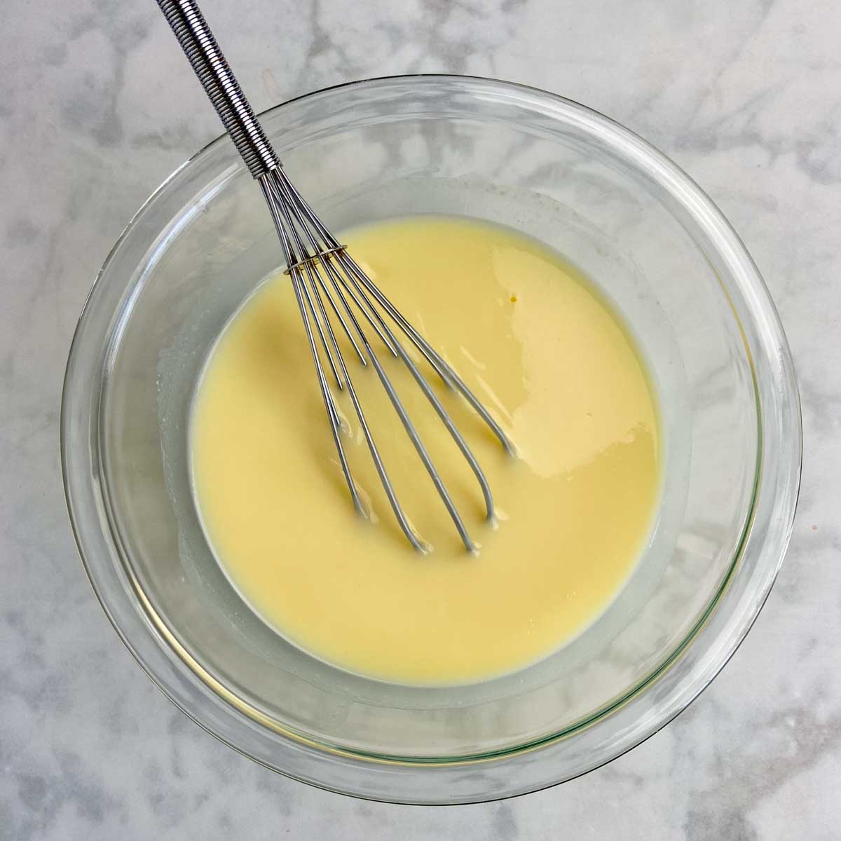 cheesecake pudding in a bowl with a whisk in it