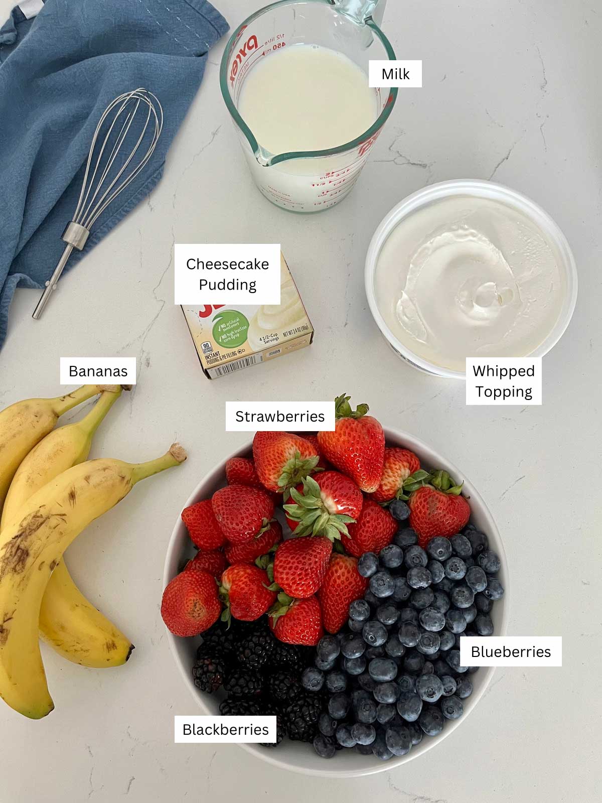 ingredients sitting on a counter needed for cheesecake fruit salad