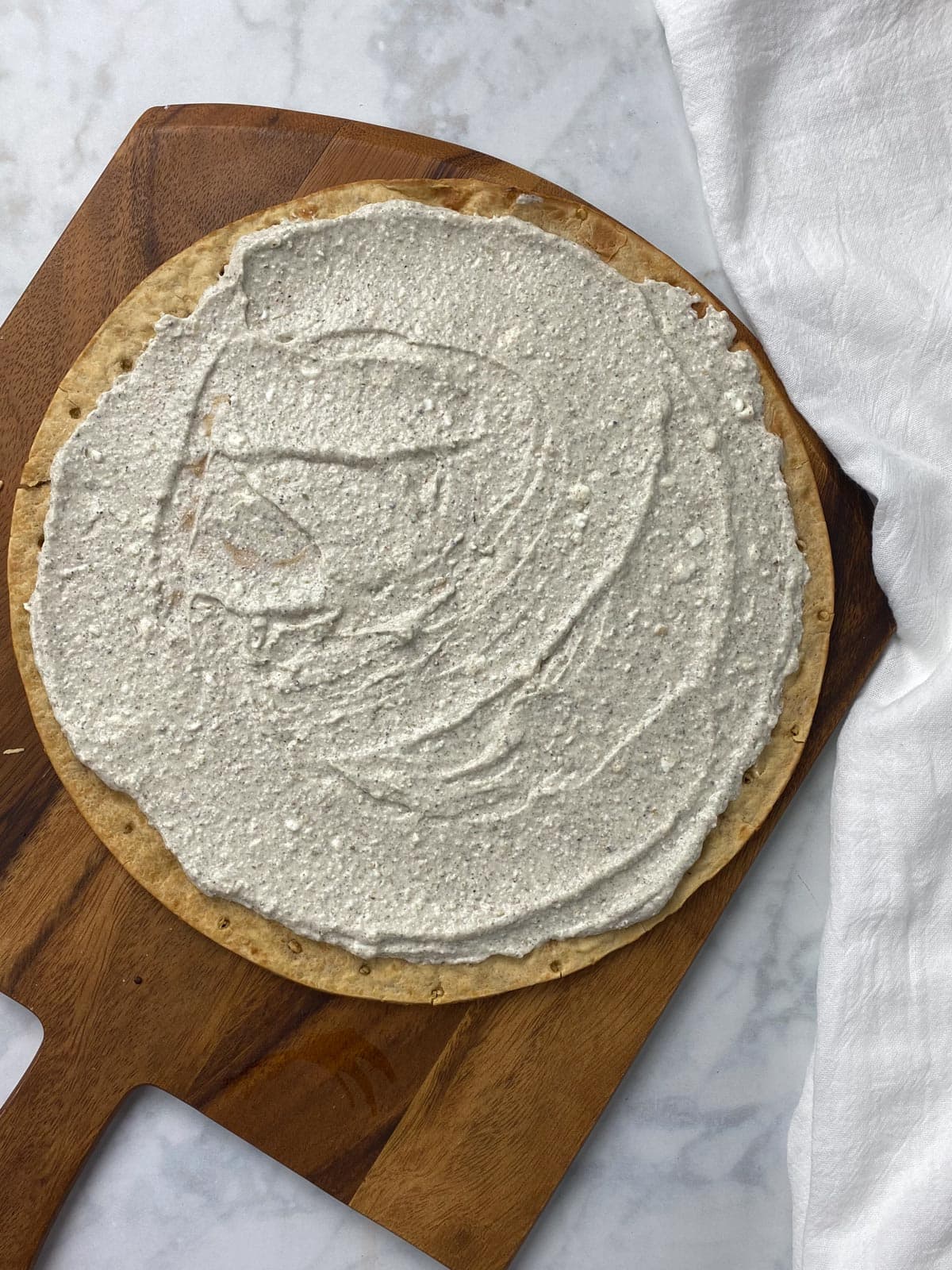 cottage cheese blend spread on a pizza crust.