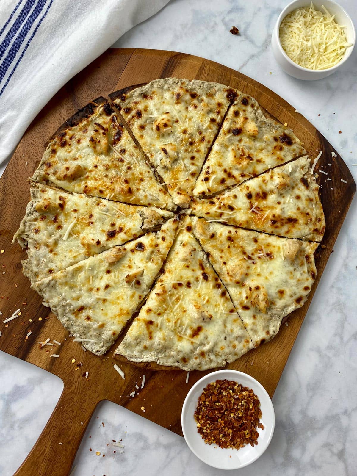 Cottage-Cheese-Pizza on a wood cutting board garnished with parmesan cheese. 