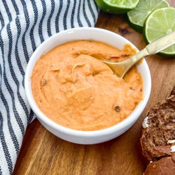 chipotle southwest sauce with limes, brown bread and a blue towel in the background.