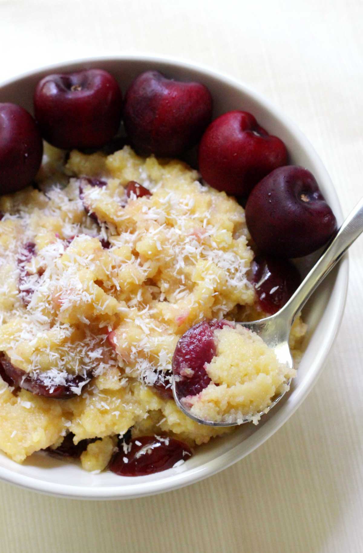 cherry polenta with a spoon taking a bite.