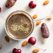 chocolate cherrie smoothie with cherries and nuts on the side.