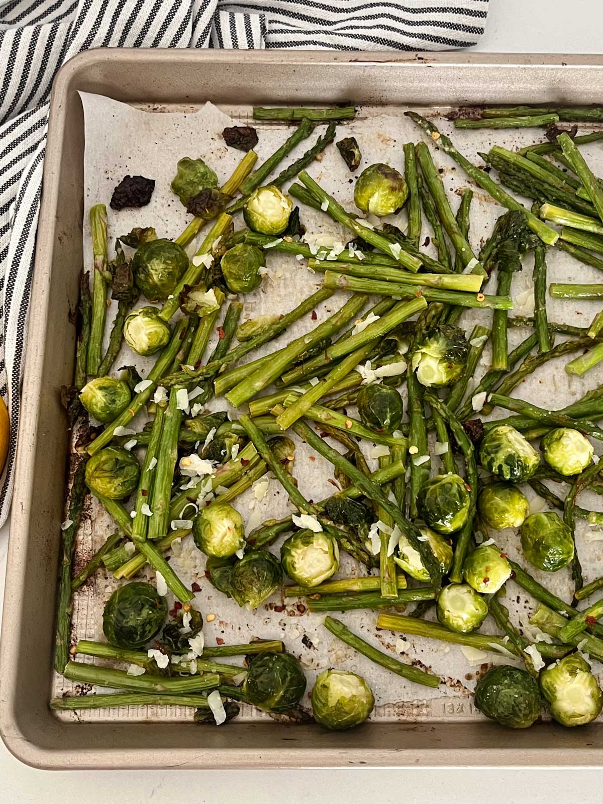 Roasted brussels sprouts and asaparagus on a sheet pan.