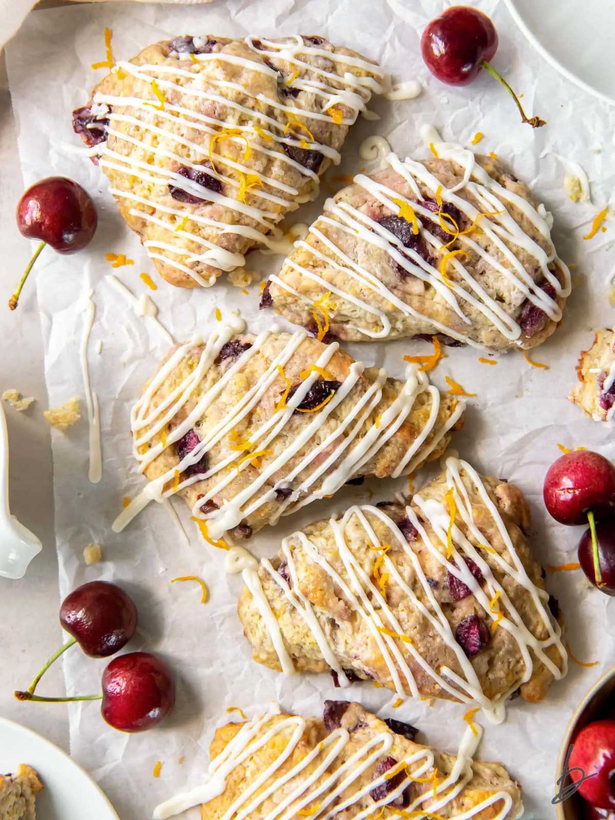 scones sitting on the table with cherries on the side