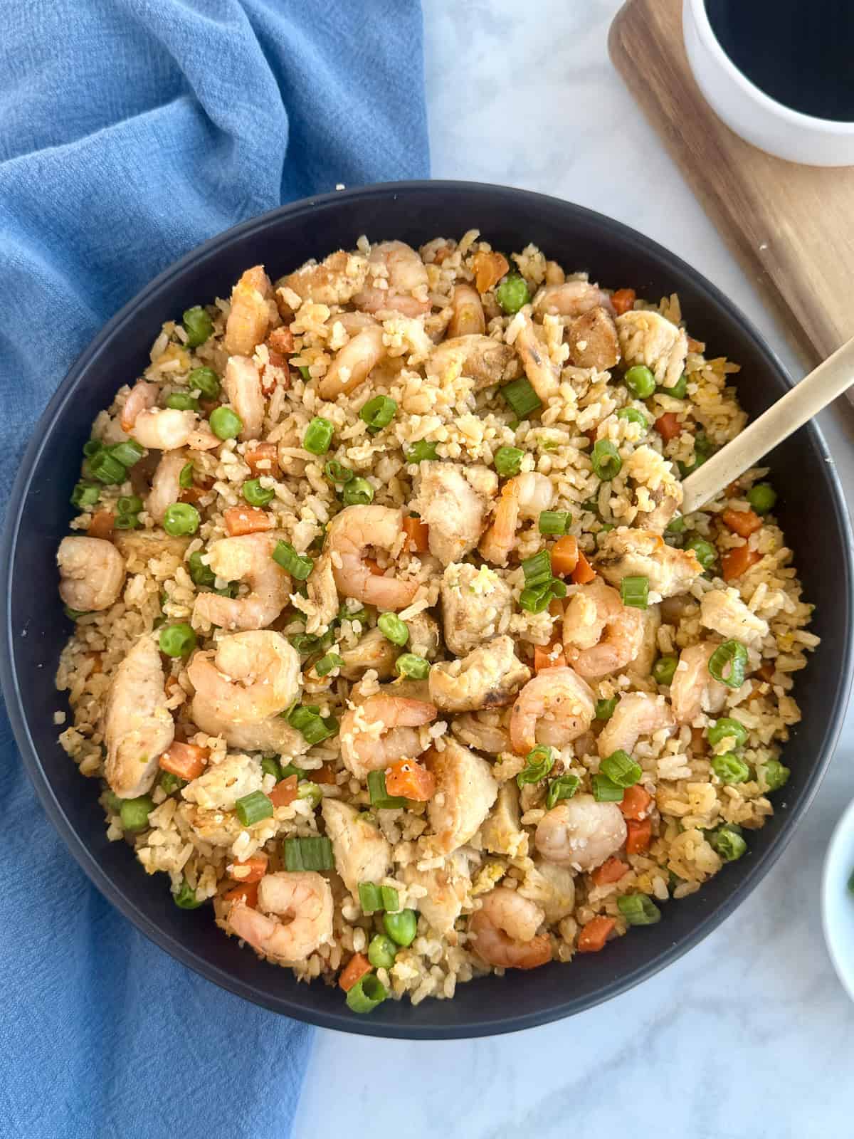 Shrimp and chicken fried rice in a bowl with a serving spoon
