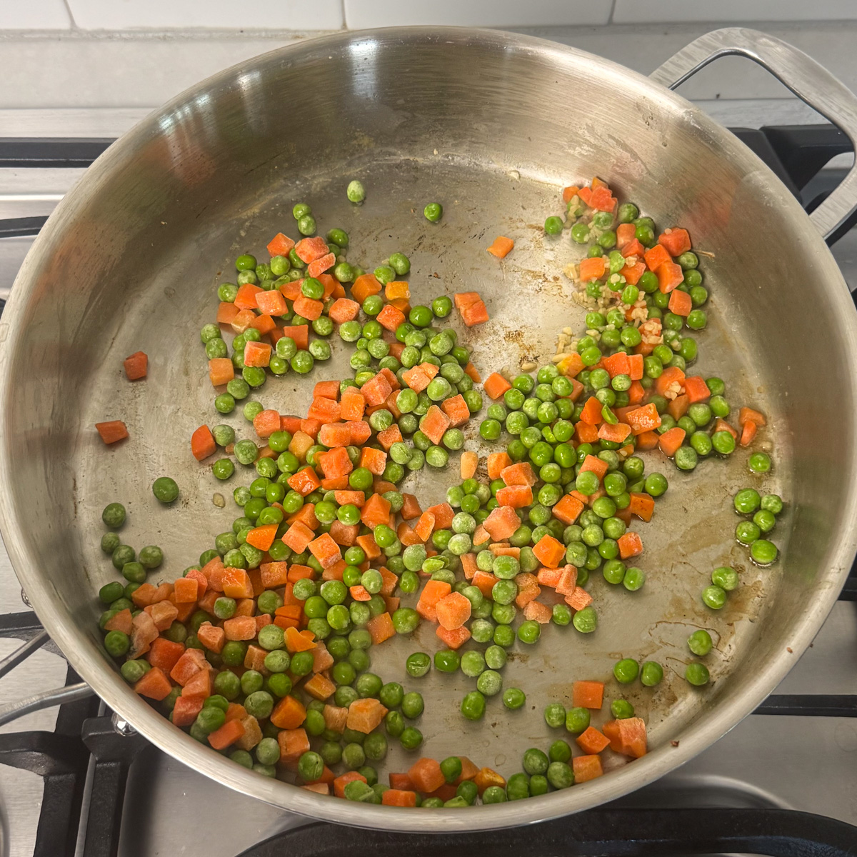 peas and carrots cooking in a pan